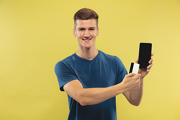 Image showing Caucasian young man\'s half-length portrait on yellow background