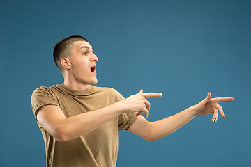 Image showing Caucasian young man\'s half-length portrait on blue background