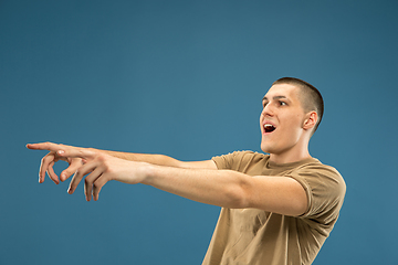 Image showing Caucasian young man\'s half-length portrait on blue background