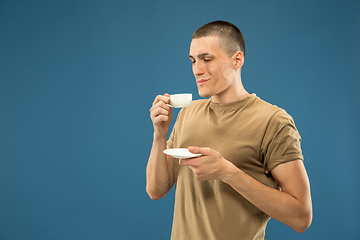 Image showing Caucasian young man\'s half-length portrait on blue background