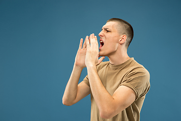 Image showing Caucasian young man\'s half-length portrait on blue background