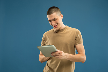 Image showing Caucasian young man\'s half-length portrait on blue background