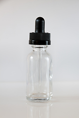 Image showing Glass dropper bottle on grey background