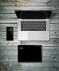 Image showing Laptop, tablet and phone set mockup on a wooden background. 3D r