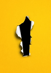 Image showing Yellow torn paper with black hole