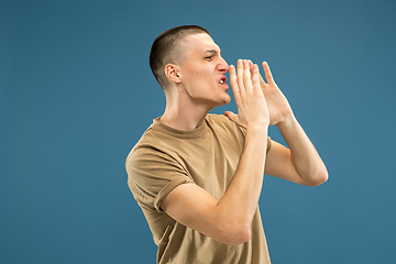 Image showing Caucasian young man\'s half-length portrait on blue background