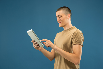 Image showing Caucasian young man\'s half-length portrait on blue background