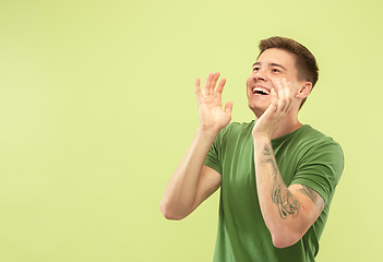 Image showing Caucasian young man\'s half-length portrait on green background