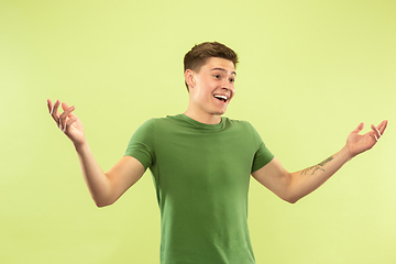 Image showing Caucasian young man\'s half-length portrait on green background