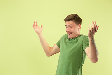 Image showing Caucasian young man\'s half-length portrait on green background