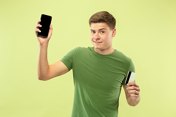 Image showing Caucasian young man\'s half-length portrait on green background