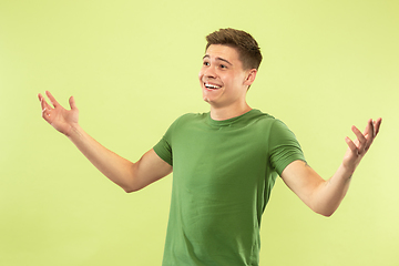 Image showing Caucasian young man\'s half-length portrait on green background