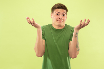 Image showing Caucasian young man\'s half-length portrait on green background