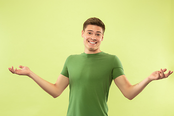 Image showing Caucasian young man\'s half-length portrait on green background