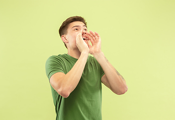 Image showing Caucasian young man\'s half-length portrait on green background