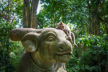 Image showing Monkey on a cow statue in the Monkey Forest, Ubud, Bali, Indones