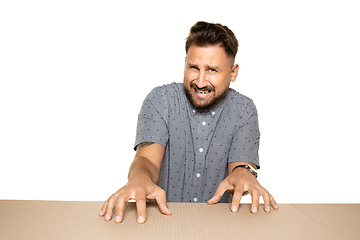 Image showing Shocked and upset man opening the biggest postal package