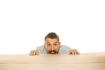 Image showing Young man opening the biggest postal package isolated on white