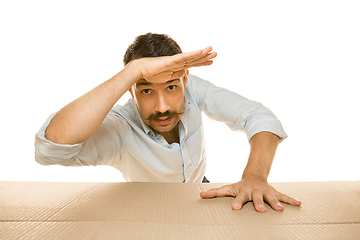 Image showing Young man opening the biggest postal package isolated on white