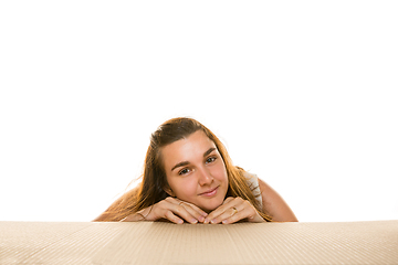 Image showing Young woman opening the biggest postal package isolated on white