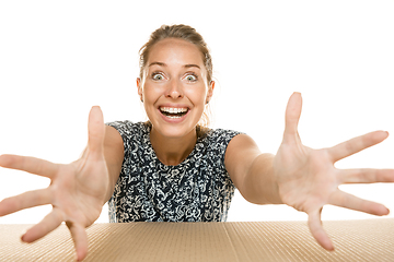 Image showing Young woman opening the biggest postal package isolated on white