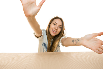 Image showing Young woman opening the biggest postal package isolated on white