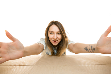 Image showing Young woman opening the biggest postal package isolated on white