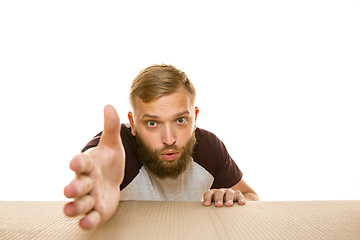 Image showing Young man opening the biggest postal package isolated on white