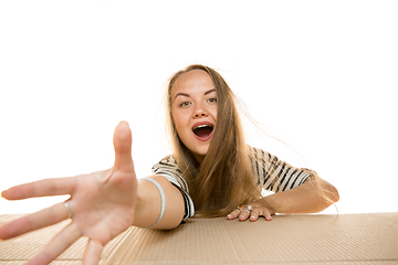 Image showing Young woman opening the biggest postal package isolated on white