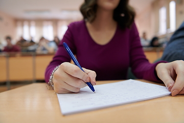 Image showing famale student using pen and notebook