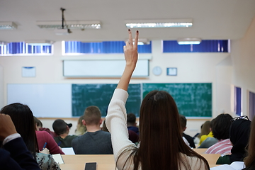 Image showing female student sitting in the class and raising hand up