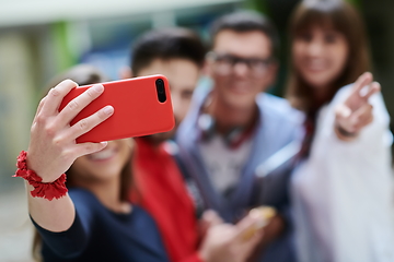 Image showing Group of multiethnic teenagers taking a selfie in school