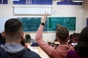 Image showing The student raises his hands asking a question in class in college