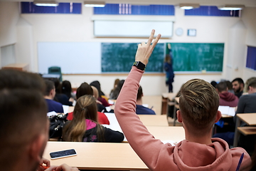 Image showing The student raises his hands asking a question in class in college