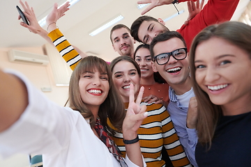 Image showing Group of multiethnic teenagers taking a selfie in school