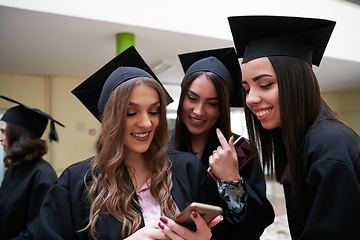 Image showing students in mortar boards using smartphone