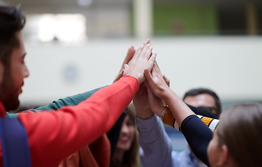 Image showing students together in problem, arm in the air