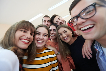 Image showing Group of multiethnic teenagers taking a selfie in school