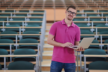 Image showing Man student working on laptop in college classroom