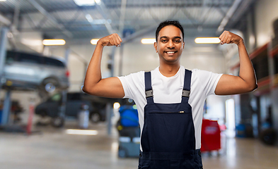 Image showing indian mechanic showing his power at car shop