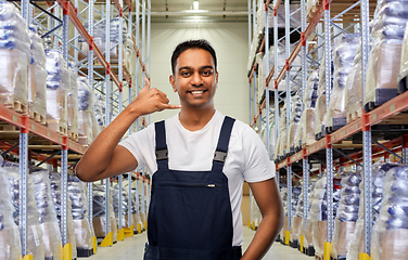 Image showing worker making phone call gesture at warehouse