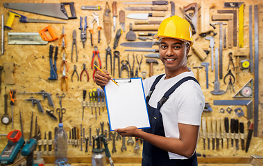 Image showing happy builder in helmet with clipboard and pencil