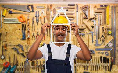 Image showing happy indian builder with ruler in shape of home