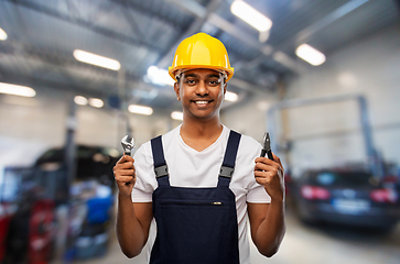 Image showing indian mechanic with wrench and pliers at car shop