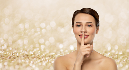 Image showing beautiful young woman holding finger on lips