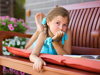 Image showing Little girl is reading a book