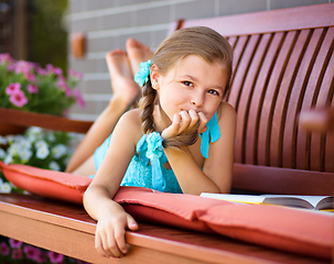 Image showing Little girl is reading a book