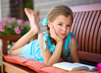 Image showing Little girl is reading a book