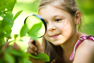 Image showing Girl is looking at tree leaves through magnifier