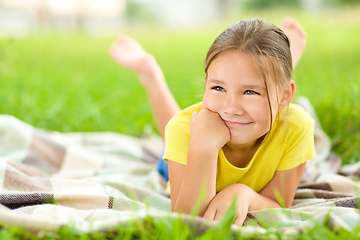 Image showing Portrait of a little girl laying on green grass